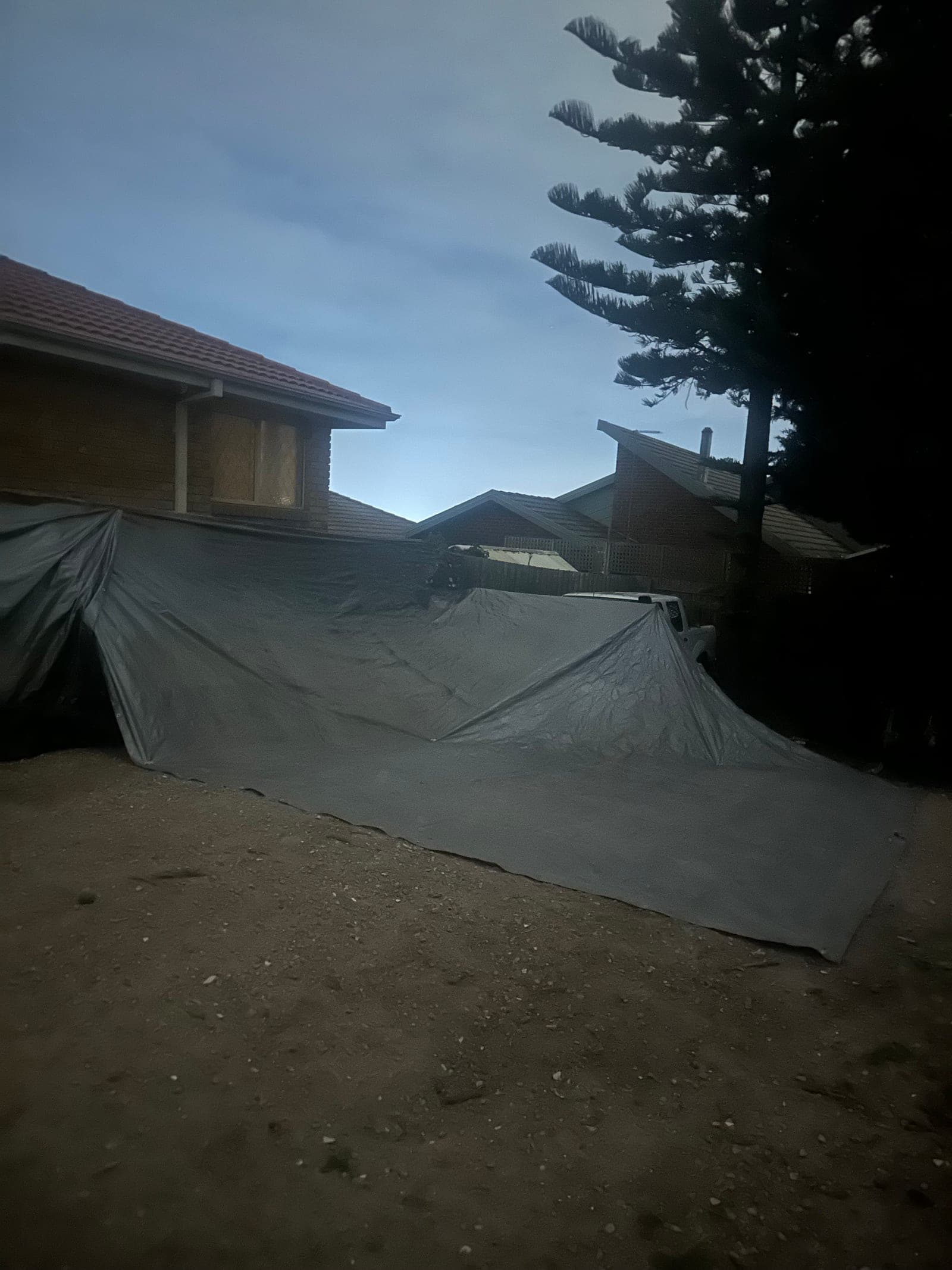 Firewood piles stored under tarps