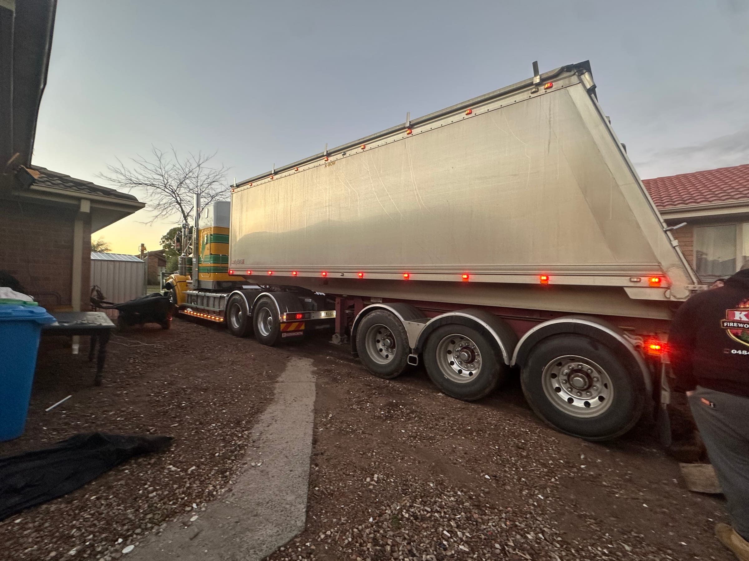 A semi-trailer parked at a residential delivery, ready to drop a bulk load